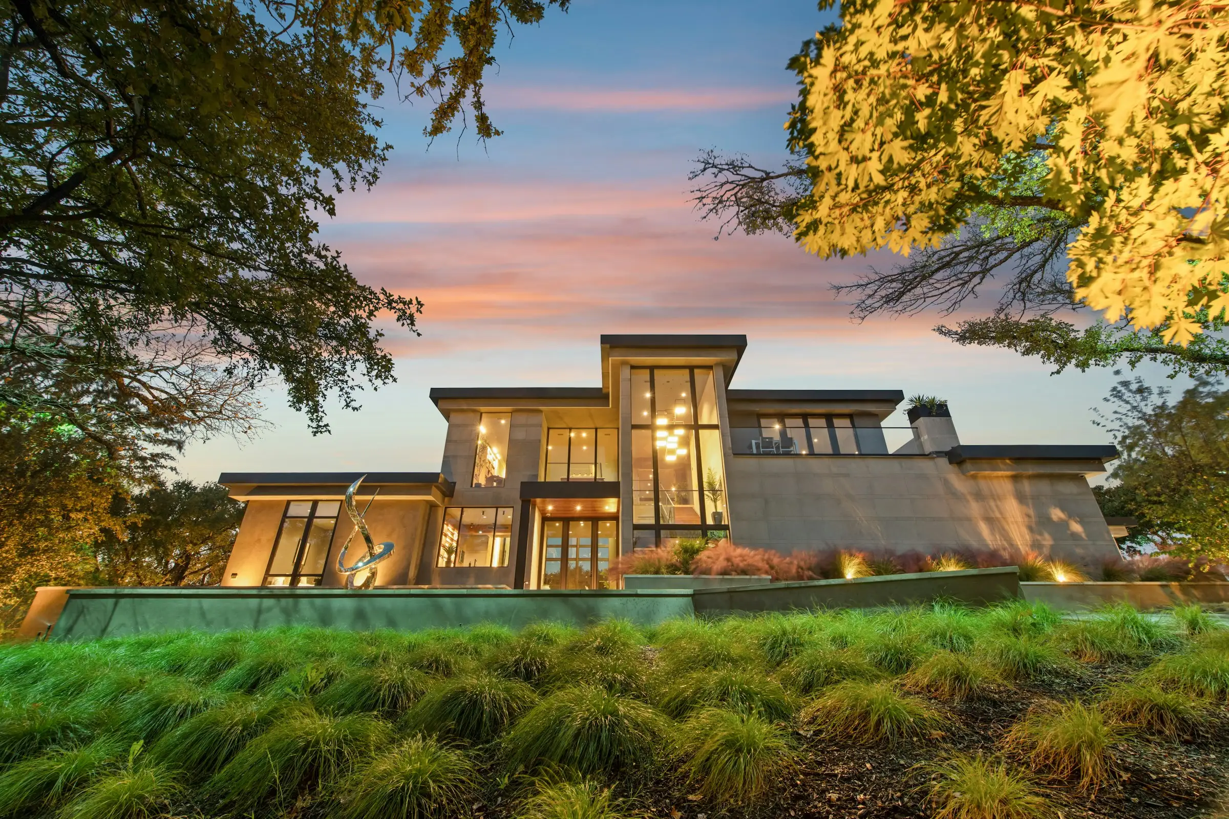 Casa con grandes ventanales iluminada al atardecer